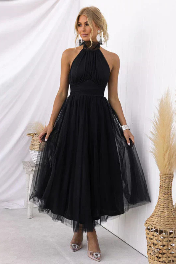 Black - Woman wearing a sleeveless tulle midi dress with a sheer halter neckline and structured corset bodice