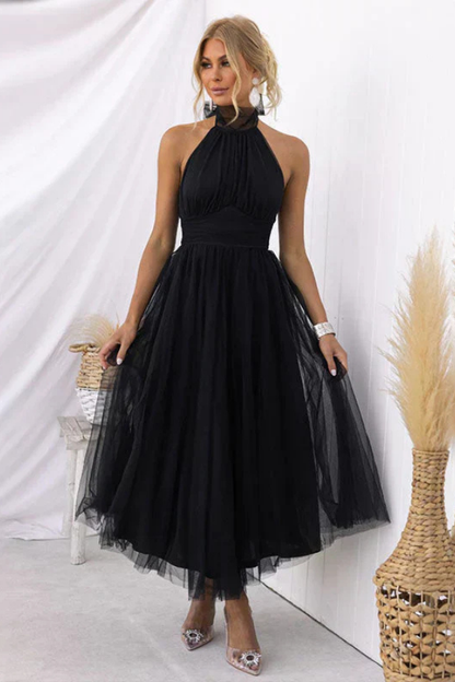 Black - Woman wearing a sleeveless tulle midi dress with a sheer halter neckline and structured corset bodice