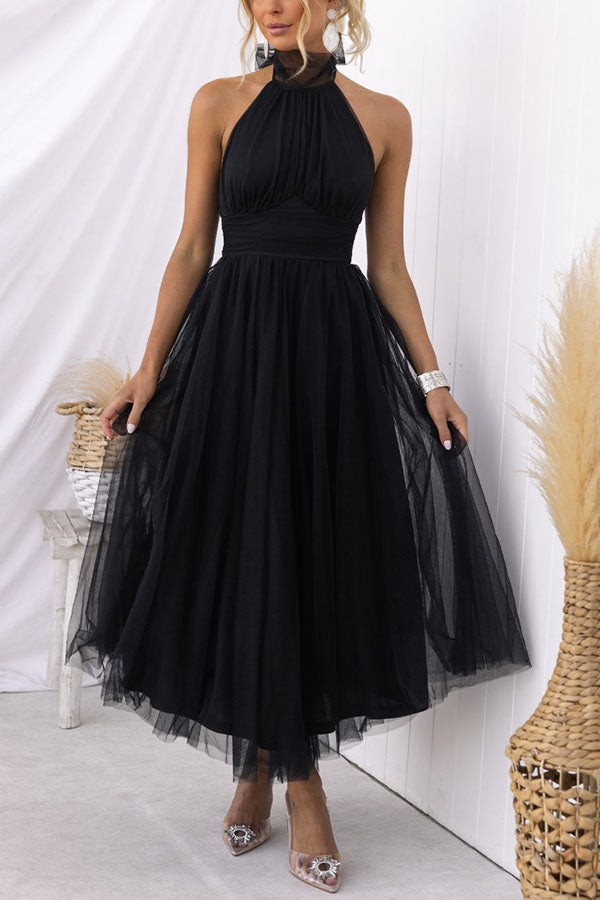 Black - Woman wearing a sleeveless tulle midi dress with a sheer halter neckline and structured corset bodice