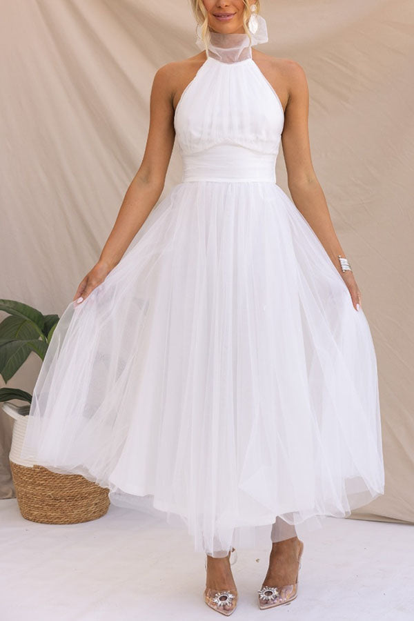 White - Woman wearing a sleeveless tulle midi dress with a sheer halter neckline and structured corset bodice