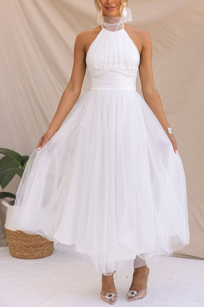 White - Woman wearing a sleeveless tulle midi dress with a sheer halter neckline and structured corset bodice