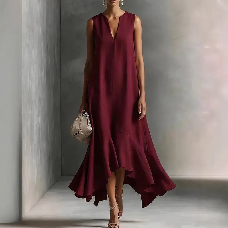 Wine Red - Woman wearing a sleeveless V-neck maxi dress with an asymmetrical ruffle hem.