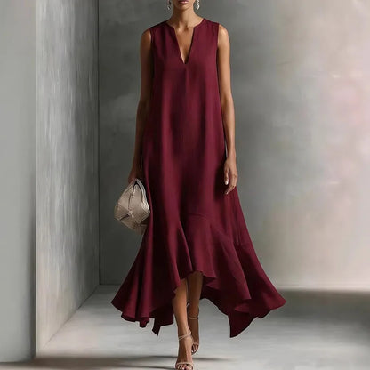 Wine Red - Woman wearing a sleeveless V-neck maxi dress with an asymmetrical ruffle hem.