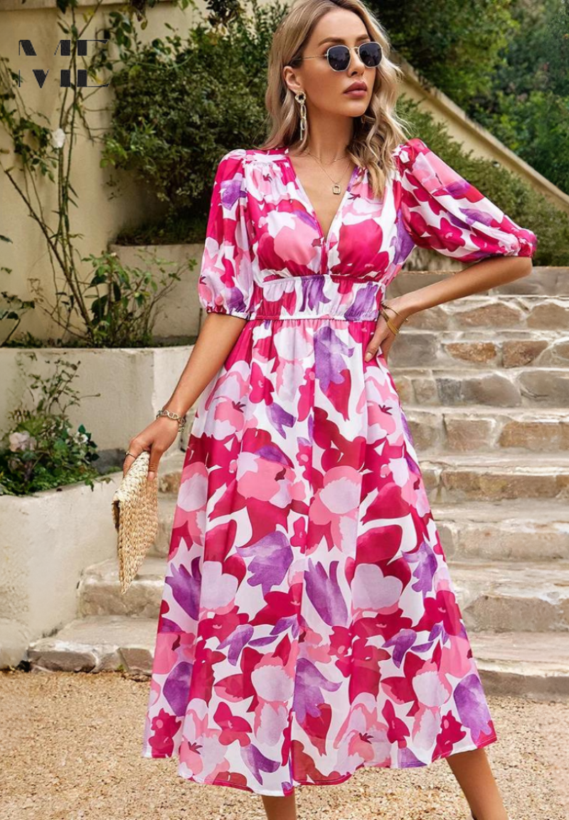 Pink - A woman wearing a vibrant, multicolored abstract floral print chiffon midi sundress with puff sleeves, a V-neckline, and a smocked waist, holding a woven straw clutch.