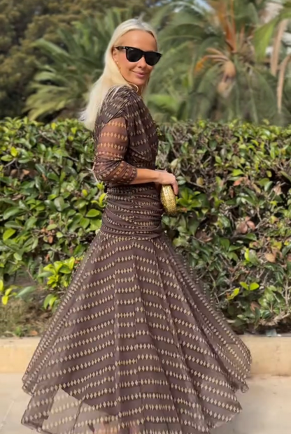 Woman in brown chiffon dress with gold accessories