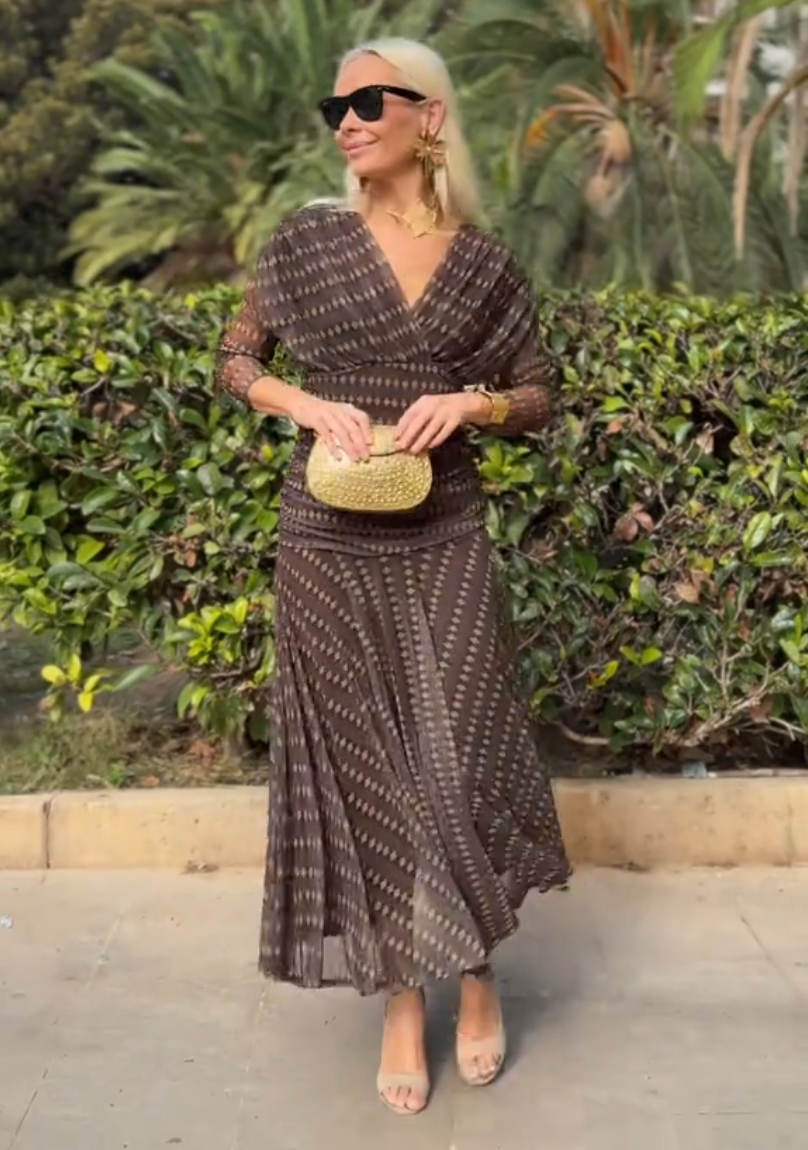 Woman in brown chiffon dress with gold accessories