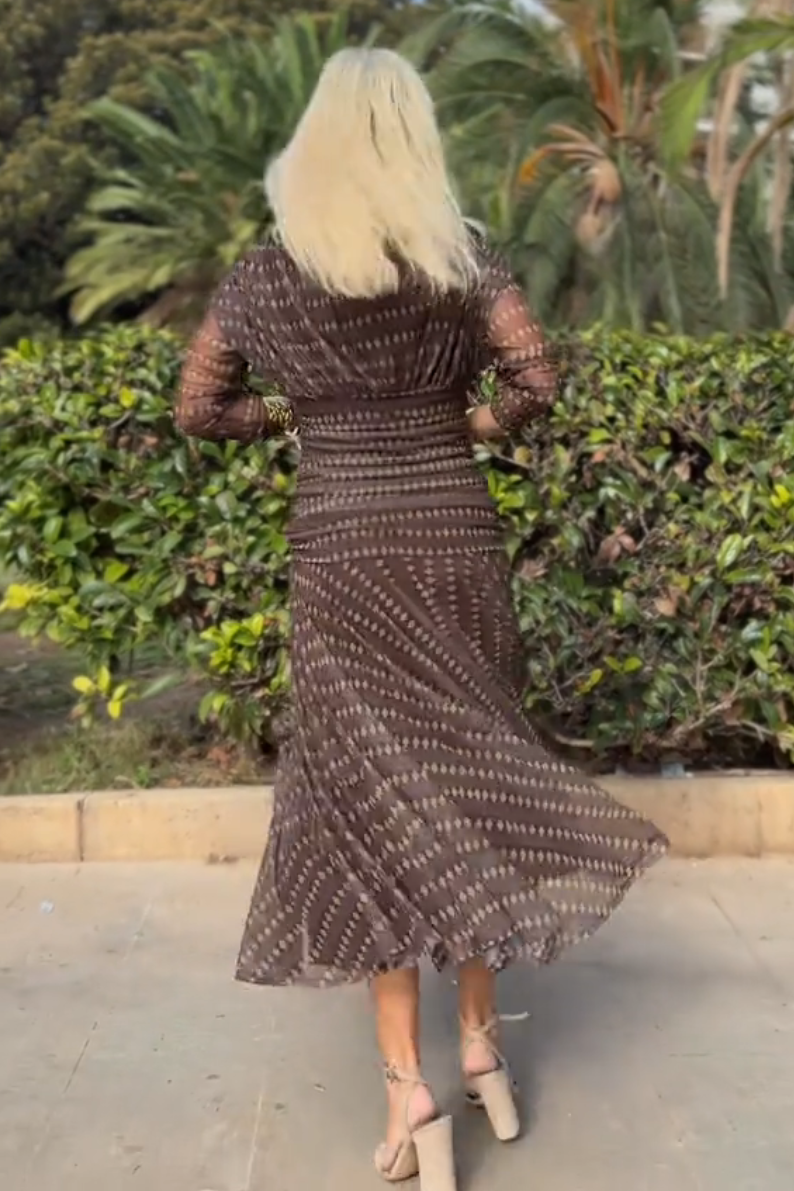 Woman in brown chiffon dress with gold accessories