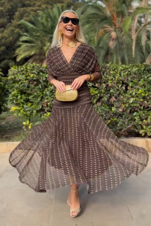 Woman in brown chiffon dress with gold accessories