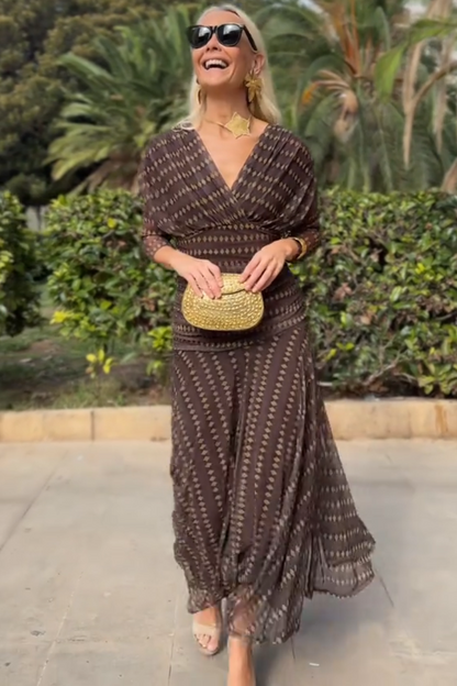 Woman in brown chiffon dress with gold accessories