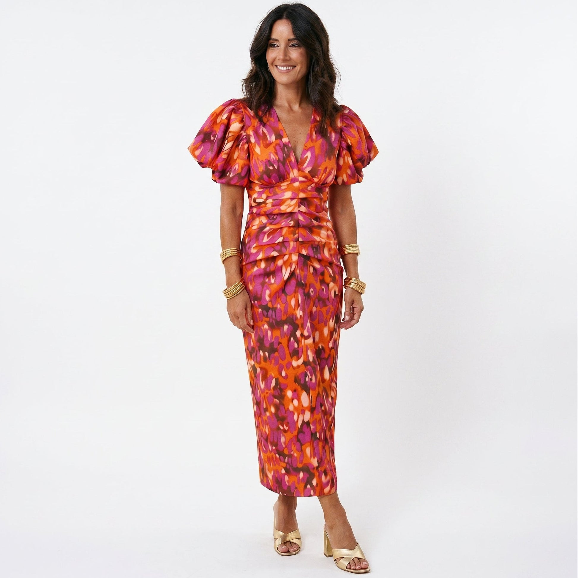 Orange - Model wearing a woven abstract pattern midi dress featuring short puff sleeves, a deep V-neckline, and a heavily ruched center bodice against a white background.