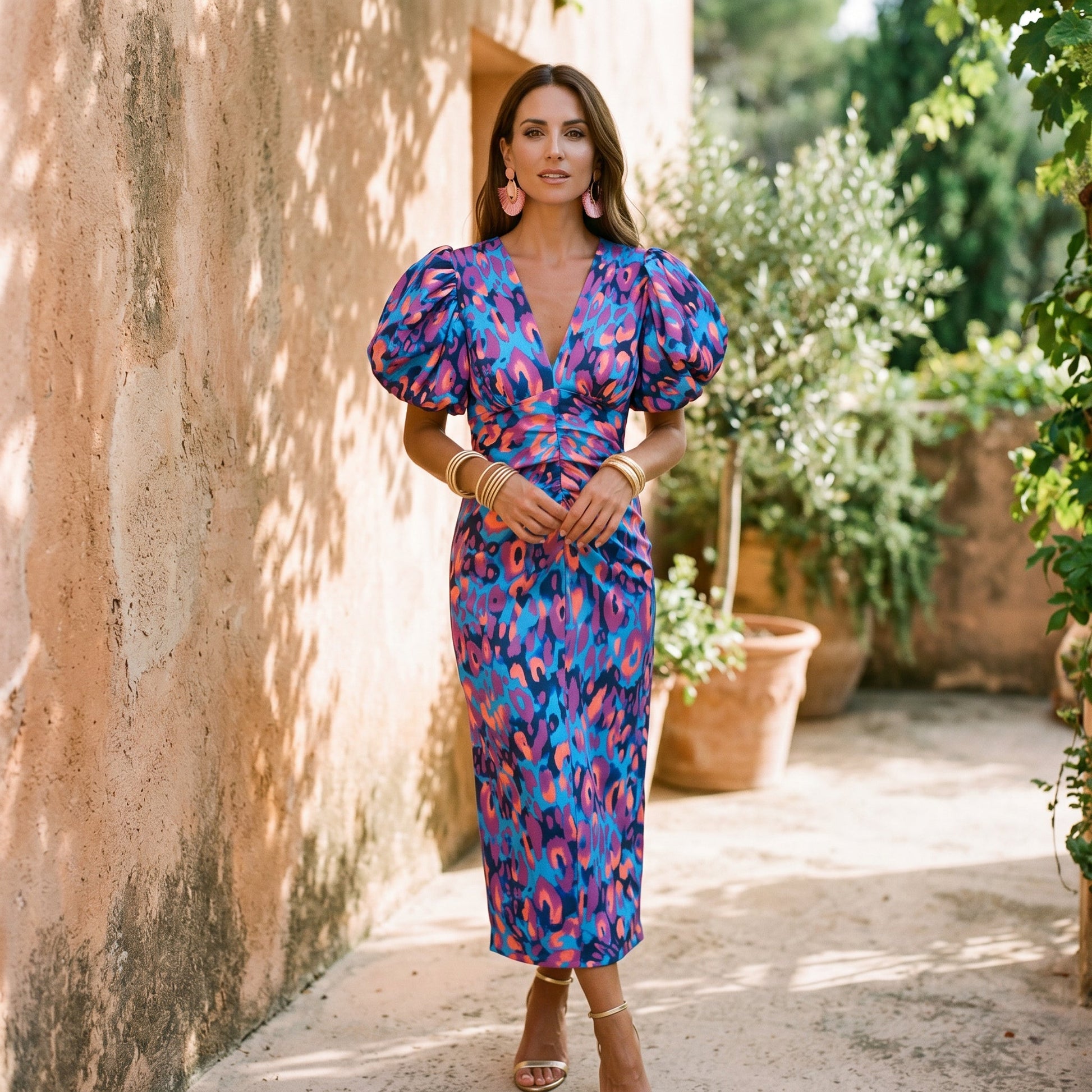 Orange - Model wearing a woven abstract pattern midi dress featuring short puff sleeves, a deep V-neckline, and a heavily ruched center bodice against a white background.