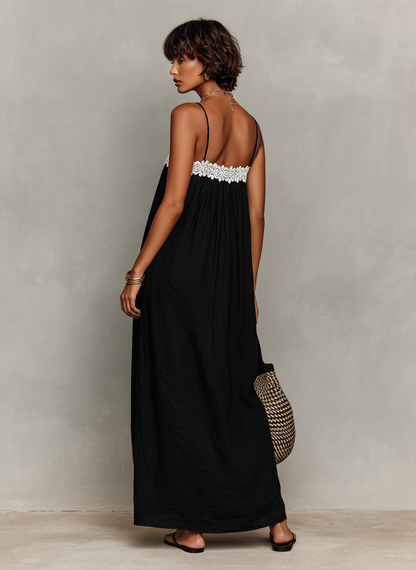 Black - Model wearing a relaxed fit woven maxi dress featuring spaghetti straps and a crochet-trimmed straight neckline, styled with a woven tote bag and sandals.