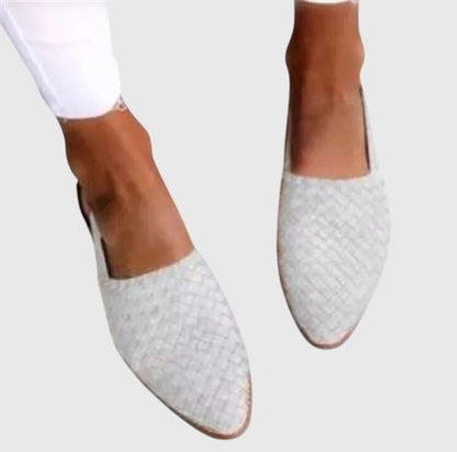 White - Women's flat slip-on mules featuring a woven faux-leather upper and closed almond toe design.