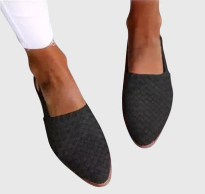 Black - Women's flat slip-on mules featuring a woven faux-leather upper and closed almond toe design.