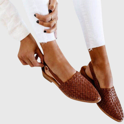 Brown - Women's flat slip-on mules featuring a woven faux-leather upper and closed almond toe design.