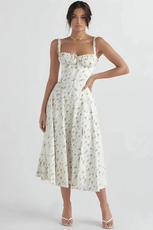 White Floral Linsay - Woman wearing a floral sweetheart midi dress with wide straps, a fitted bodice, and a flowing A-line skirt with a front slit.