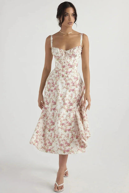 Pink Print Linsay - Woman wearing a floral sweetheart midi dress with wide straps, a fitted bodice, and a flowing A-line skirt with a front slit.