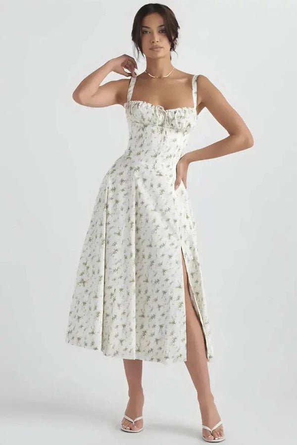 White Floral Linsay - Woman wearing a floral sweetheart midi dress with wide straps, a fitted bodice, and a flowing A-line skirt with a front slit.