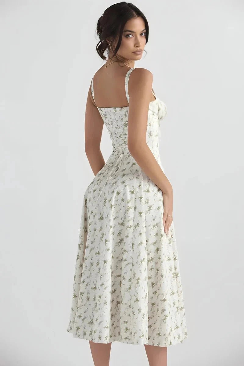 White Floral Linsay - Woman wearing a floral sweetheart midi dress with wide straps, a fitted bodice, and a flowing A-line skirt with a front slit.