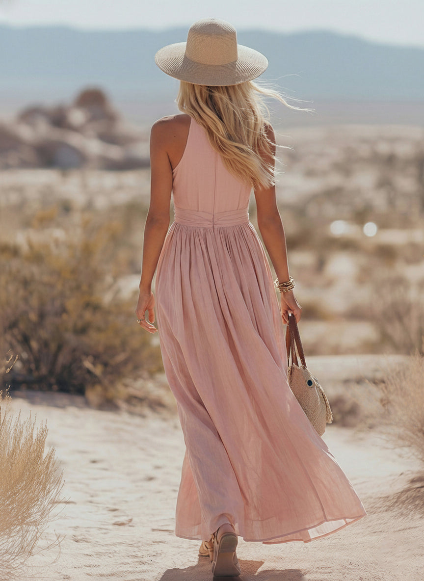 Teal - Woman walking outdoors in a desert landscape wearing a lightweight, sleeveless plunging V-neck maxi dress with a wide banded waist and side button details.