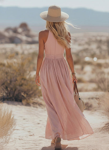 Teal - Woman walking outdoors in a desert landscape wearing a lightweight, sleeveless plunging V-neck maxi dress with a wide banded waist and side button details.