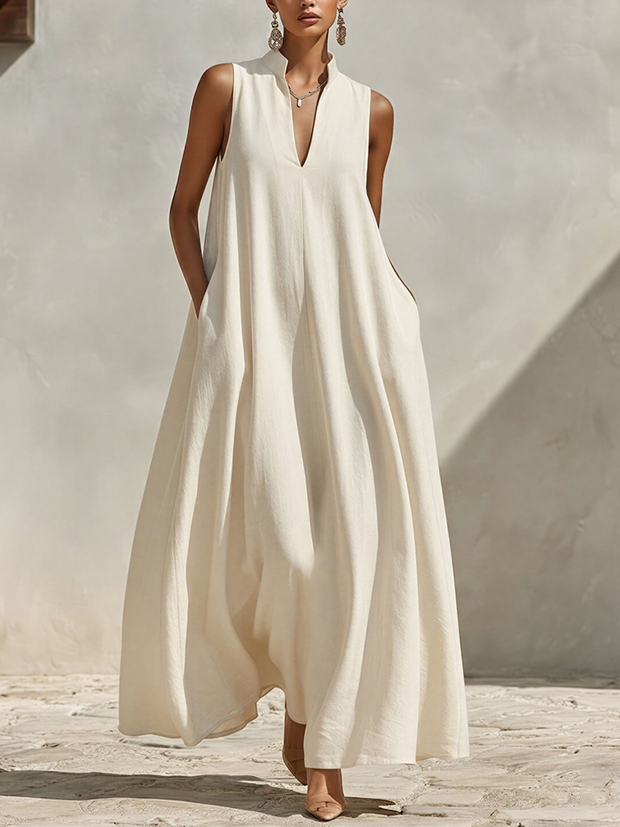 Cream - A model wearing a voluminous, sleeveless woven maxi dress with a deep V-neck and stand collar, standing outdoors.