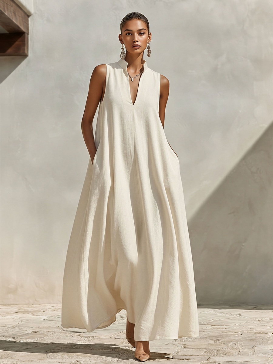 Cream - A model wearing a voluminous, sleeveless woven maxi dress with a deep V-neck and stand collar, standing outdoors.