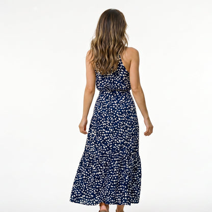 Red - Woman wearing a spotted halter neck maxi dress with a tie waist and tiered skirt.