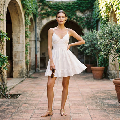 M - Woman wearing a solid woven tiered mini dress with spaghetti straps and a V-neckline, featuring a fitted bodice and flared skirt.
